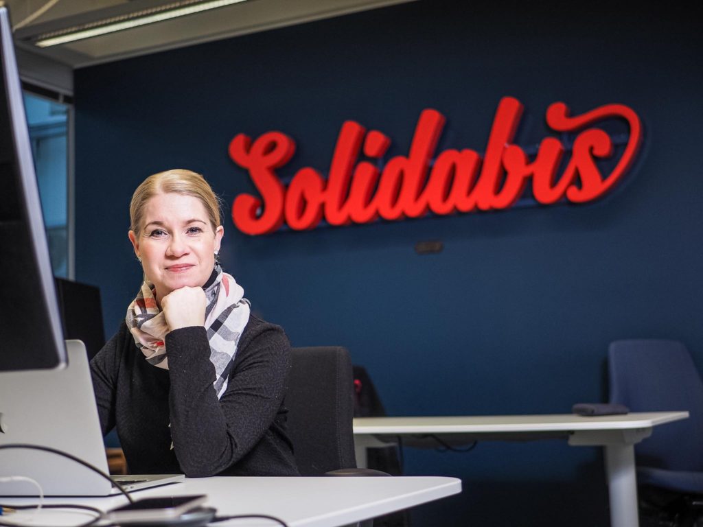Outi Mattila istumassa työpöydän ääressä Solidabiksen toimistolla.