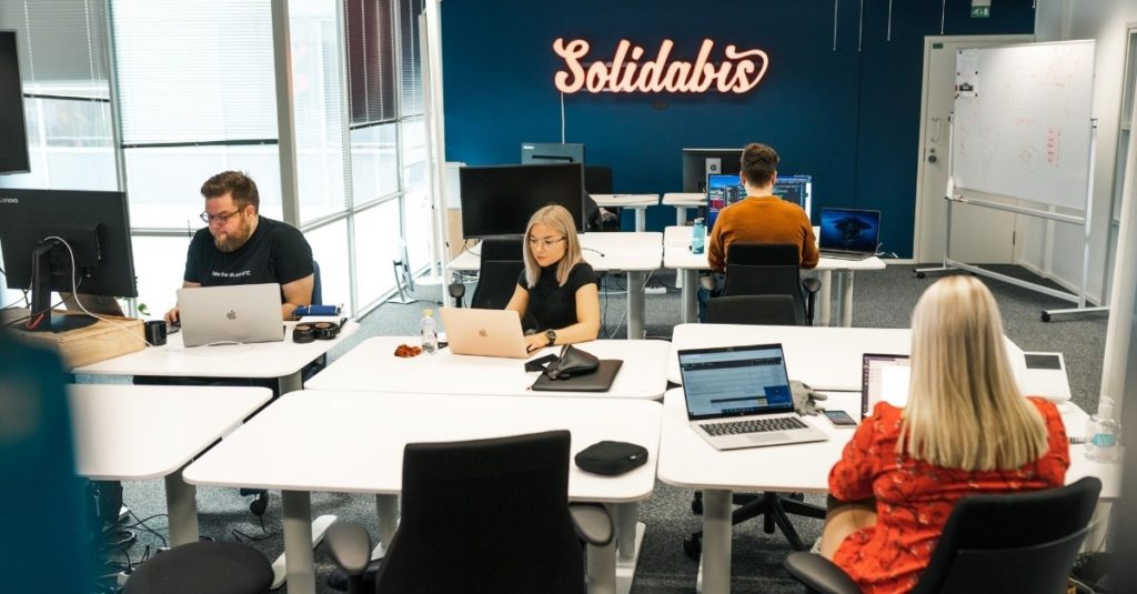 Kuvituskuva, avoin työpaikka ohjelmistokehittäjiä: Solidabislaisia työpöytien ääressä meidän Mikonkadun toimistollamme