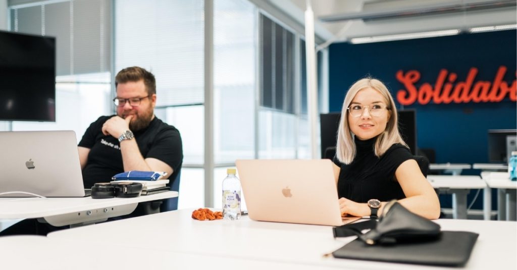Kuvituskuva: Solidabiksen työntekijät Sara ja Veli-Pekka Solidabiksen toimistolla työskentelemässä.