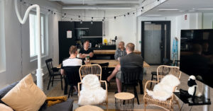 Kuva Oulun toimiston kahvihetkestä, neljä koodaria pöydän ääressä ja miljöönä avokeittiö ja sohvahuone